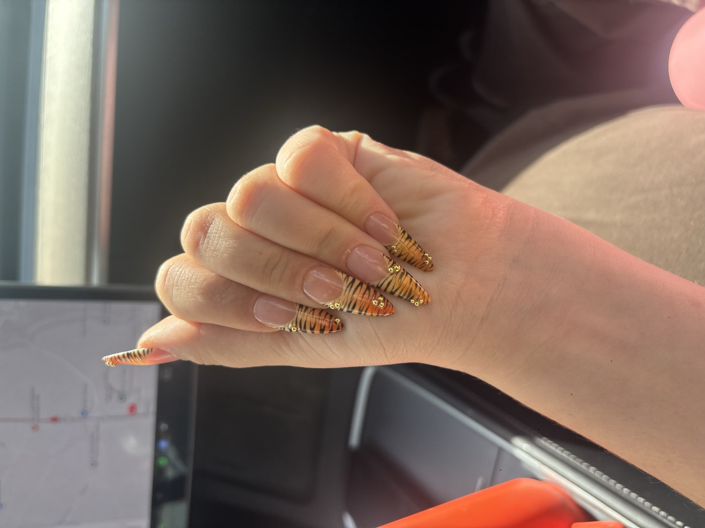 Almond press-on nails with tiger-stripe french tips and gold bead accents